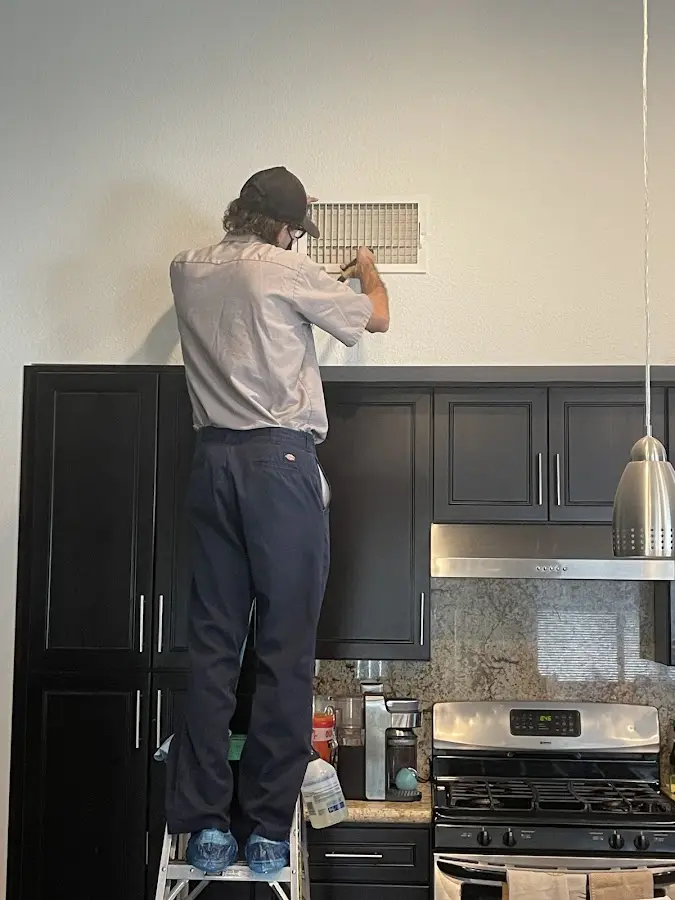 Technician inspecting an air vent during HVAC service in Keyport